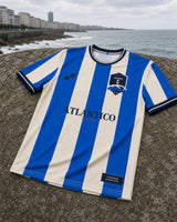 Camiseta Riazor 2026 frontal sobre piedra junto al Atlántico