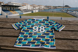Espalda de la camiseta Club Costero 98 con contexto de campo costero
