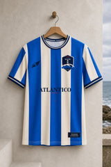 Vista frontal de la camiseta Riazor 2026 colgada frente al mar