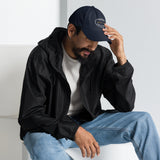 Gorra Fisterra CF Azul marino - hombre con gorra en look urbano sentado. Mockup oficial Printful, Costa da Morte.