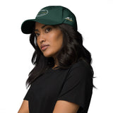 Gorra Fisterra CF Verde abeto - mujer con gorra en retrato premium lateral. Mockup oficial Printful, Costa da Morte.