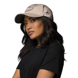 Gorra Fisterra CF Arena - mujer con gorra en retrato premium lateral. Mockup oficial Printful, Costa da Morte.