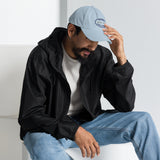 Gorra Fisterra CF Azul cielo - hombre con gorra en look urbano sentado. Mockup oficial Printful, Costa da Morte.