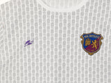 Camiseta Castilla Blanca 1986 - detalle del patrón heráldico en morado y dorado