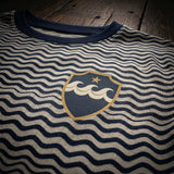 Detalle del escudo y patrón de ondas de la camiseta C.D. Rías Baixas 92