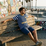 Modelo sentado con la camiseta Pacific Sun F.C. 94 Edición Sol frente al paseo maritimo